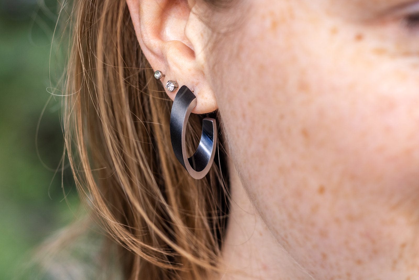 Oorbellen OLIVIA zwart gedragen | ovale creolen met matte afwerking | CLIC by Suzanne