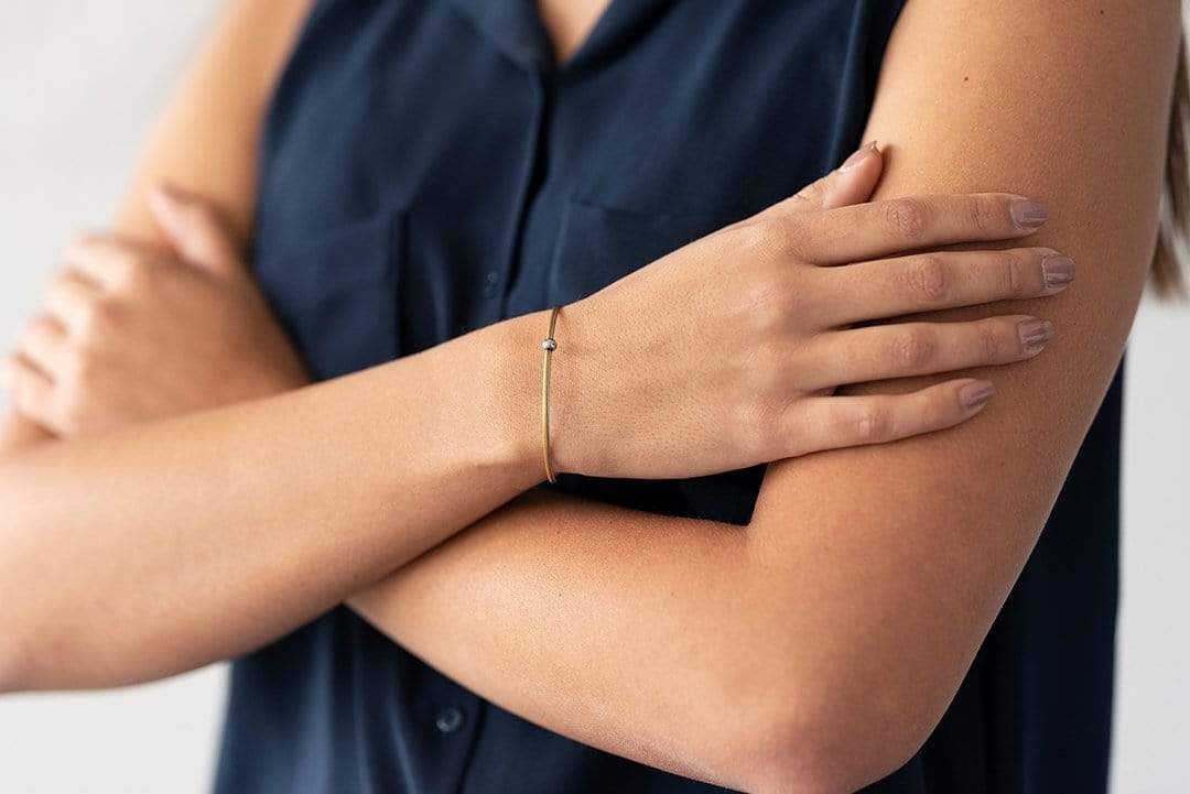 Vrouw draagt goudkleurige Thinking of You bolletje armband | CLIC by Suzanne